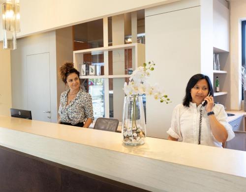 Due donne in piedi dietro un bancone in un ufficio di Hotel Constellation a Lido di Savio