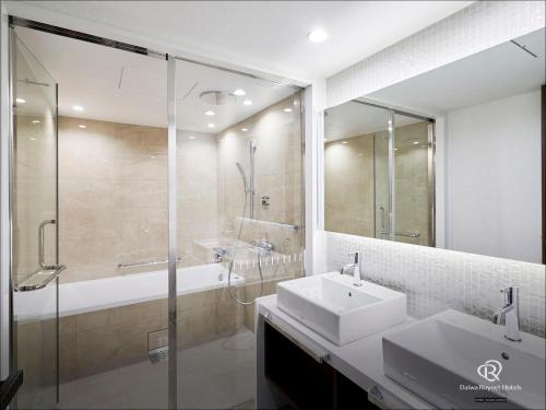 a bathroom with a sink and a shower and a tub at Daiwa Roynet Hotel Sendai Nishiguchi PREMIER in Sendai