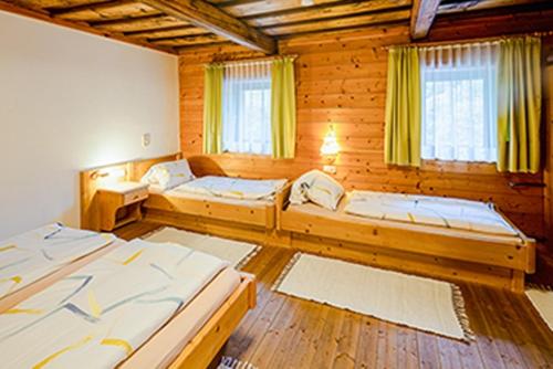 een kamer met 3 bedden in een houten hut bij Appartements Scharzenberger und Hinteregg in Schladming