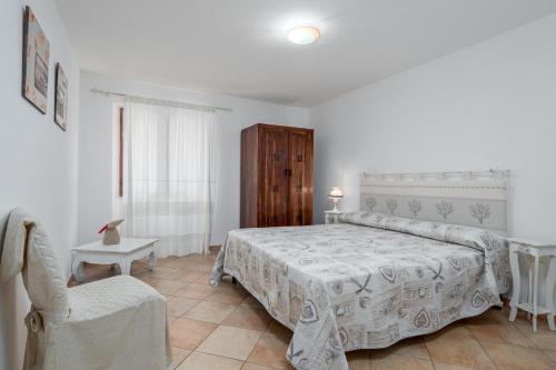 a bedroom with a bed and a chair at Casa Bice 2 in Golfo Aranci