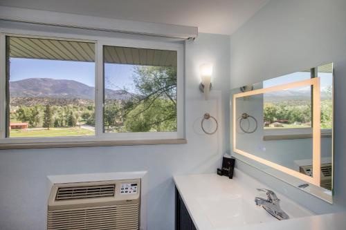 a bathroom with a sink and a mirror and a window at Silver Ridge Lodge in Salida