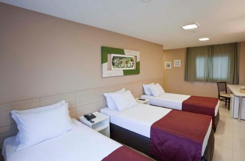 A bed or beds in a room at Grande Hotel Itaguaí
