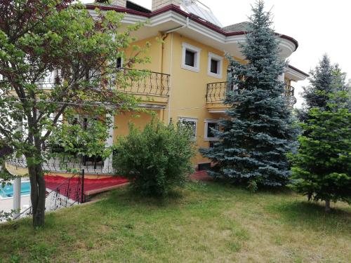 a yellow house with a christmas tree in front of it at Trabzon manzaralı havuzlu villa in Trabzon