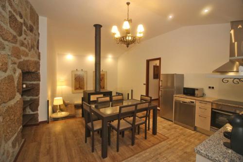 a kitchen with a table and chairs in a room at Casa da Lameira II by Gerês Casas in Geres