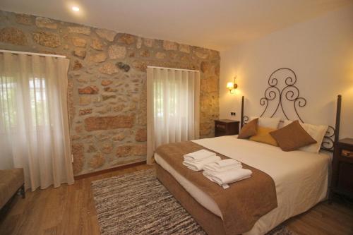 une chambre avec un grand lit avec des serviettes dessus dans l'établissement Casa da Lameira II by Gerês Casas, à Gerês