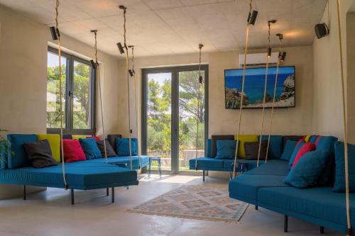 a living room with blue couches and windows at Moro Inn in Korčula