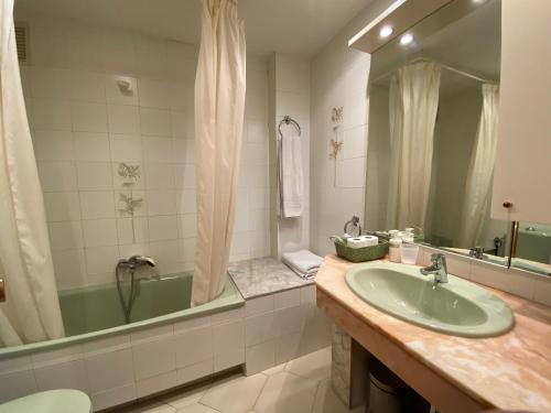 uma casa de banho com uma banheira verde e um lavatório em Apartamento con piscina en 1ª línea de playa en Salou em Salou