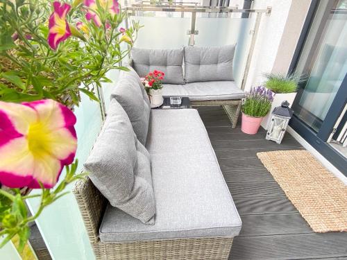 a patio with a couch and some plants and flowers at Silver Apartments in Świnoujście