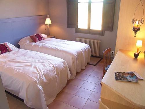 a hotel room with two beds and a window at Casa rural con jardín privado! in Navata