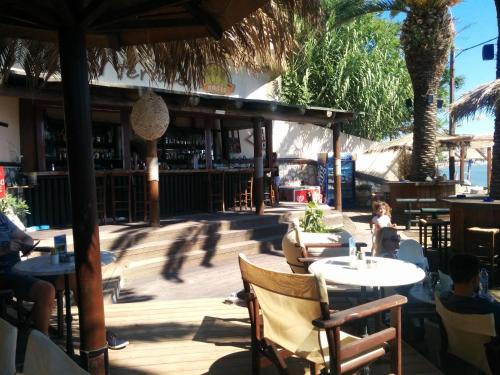 a patio with tables and people sitting at a restaurant at Oasis - Harbor House in Lithakia