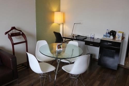 a dining room with a glass table and white chairs at Fortune Inn Sree Kanya, Visakhapatnam - Member ITC Hotels' Group in Visakhapatnam