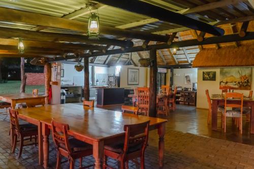 a dining room with wooden tables and chairs at Crocodile Bridge Safari Lodge in Komatipoort