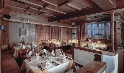 a restaurant with tables and chairs in a room at Hotel Kathrin in Grossarl