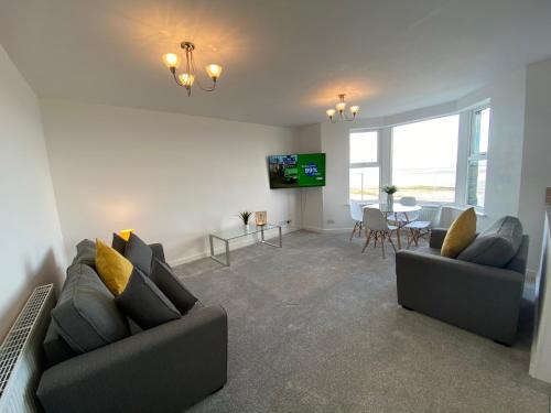 a living room with two couches and a dining room at Eden Escapes Serviced Apartments in Morecambe