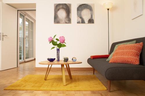a living room with a couch and a table with flowers at Villa Maria in Luzern