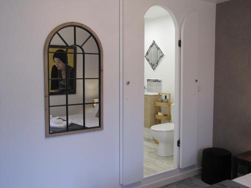 La salle de bains est pourvue d'un miroir et de toilettes. dans l'établissement C'est la vie, à Saint-Malo-des-Trois-Fontaines
