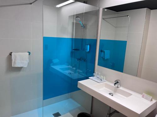 a bathroom with a sink and a glass shower at Ibis Styles Madrid Prado in Madrid