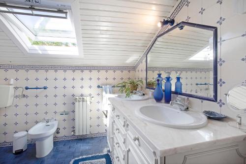 Baño con 2 lavabos y espejo en Casa Alfeizerão, en Alfeizerão