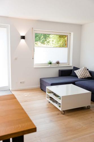 a living room with a blue couch and a white coffee table at Ferienwohnung Kurpark Brilon am Rothaarsteig in Brilon
