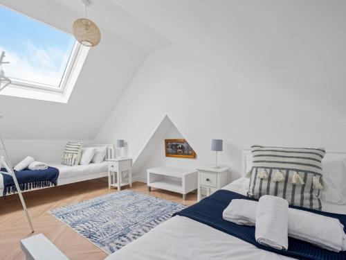 a white room with two beds and a window at Pass the Keys 3 bed Scandi Heaven minutes from the beach in Whitstable