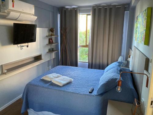 Un dormitorio con una cama azul con toallas. en Frente Mar - Duas Suítes no C.Branco, en João Pessoa