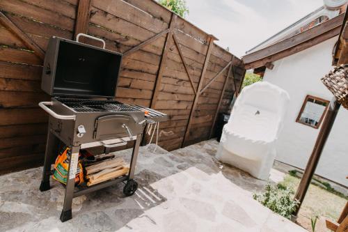 a grill with a computer on a cart in a backyard at Holiday Home Bonum in Bihać