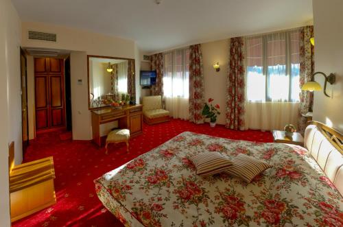 a hotel room with a large bed and a mirror at Boutique Hotel VSK Kentavar in Dryanovo