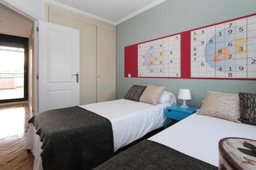 um quarto com 2 camas e uma grande parede com equações em Apartamentos Cinco Rosas em Madrid