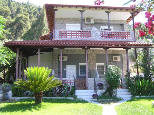 a house with a balcony on the front of it at Villa Dallas-Beach,Bike & Gym in Vourvourou