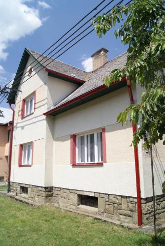 a white house with red trim at Dům u splavu in Karolinka