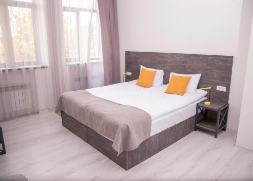 a bedroom with a large bed with orange pillows at Popock Goris in Goris