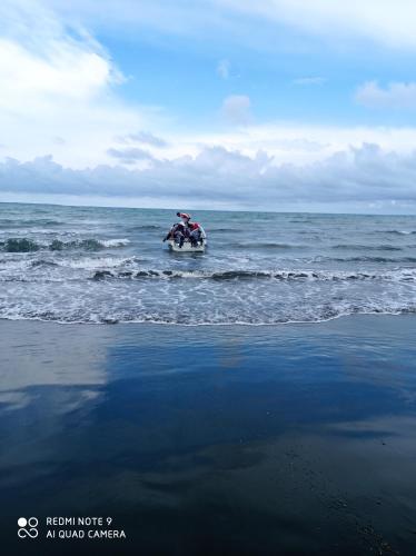 a person riding a motorcycle in the ocean at HOSTAL BELLEZA TROPICAL in Moñitos