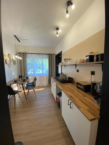 a kitchen with white cabinets and a dining room with a table at Panda apartmán Frýdštejn in Frýdštejn