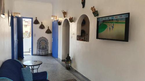 a living room with a tv on a wall at Dar ziane 1 in El Jadida