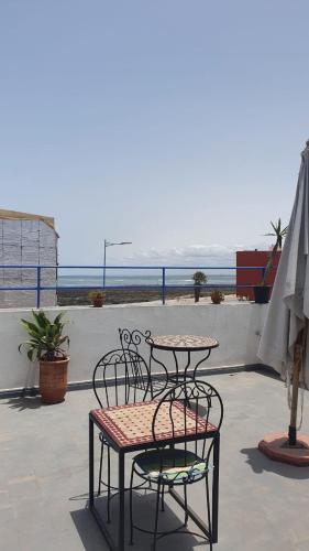 a patio with tables and chairs and an umbrella at Dar ziane 1 in El Jadida