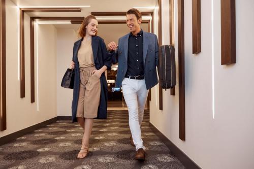 a man and a woman walking down a hallway at Grand Hotel Palace in Thessaloniki