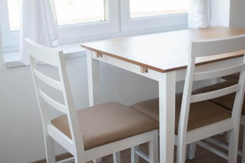 a white table and two chairs at a white desk at Casa Abiiani in Oradea