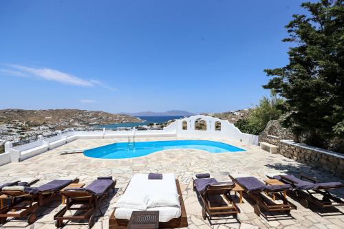 米克諾斯城的住宿－Mykonos in White，一个带椅子的庭院和一个游泳池