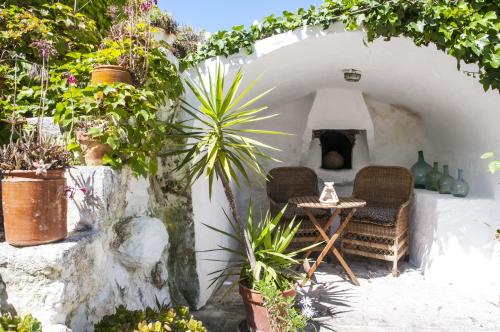a room with two chairs and a table with plants at Hotel Rural Biniarroca - Adults Only in Sant Lluis