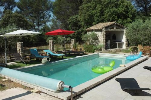 a swimming pool with inflatable chairs and a gazebo at Sous le Micocoulier in Mérindol