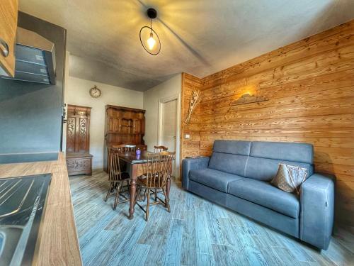 ein Wohnzimmer mit einem blauen Sofa und einem Tisch in der Unterkunft Il nido dello Chaberton in Cesana Torinese