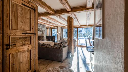 une porte ouverte sur une chambre avec un canapé et des fenêtres dans l'établissement Chalet Entre Nous, à Chamonix-Mont-Blanc