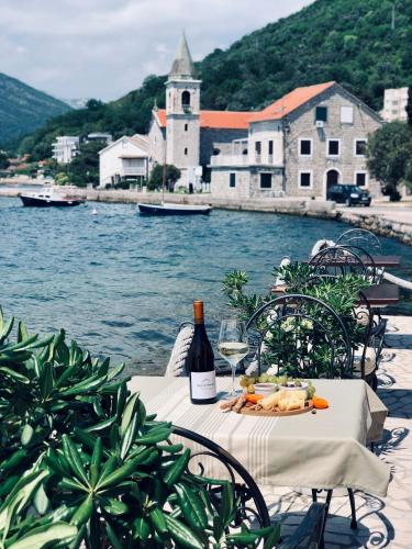 a table with a bottle of wine and a glass at Guesthouse Giraffe in Tivat