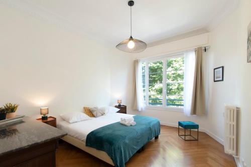 une chambre avec un lit et une grande fenêtre dans l'établissement Maison Bianchi - Victor Hugo, à Nice