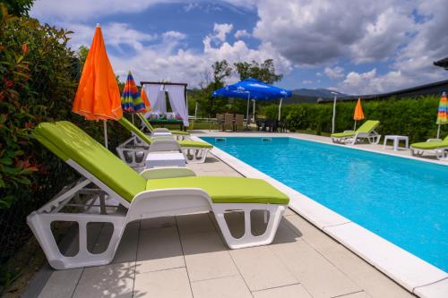 a pool with lounge chairs and umbrellas next to it at Holiday Home Bonum in Bihać