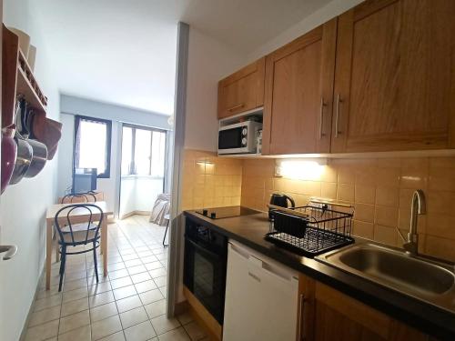 une cuisine avec un évier et une cuisinière four supérieur dans l'établissement Studio cosy avec parking privé, au centre, proche thermes et lac - FR-1-555-20, à Aix-les-Bains