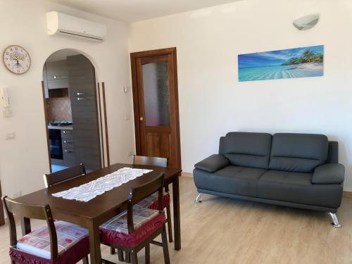 salon ze stołem i kanapą w obiekcie Smeralda w mieście Olbia