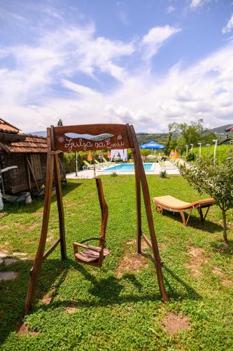 a sign in the grass next to a pool at Holiday Home Bonum in Bihać