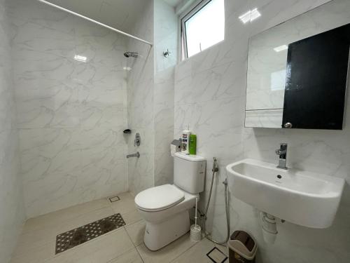 a white bathroom with a toilet and a sink at Delight Homestay Twin Galaxy Studio Room in Johor Bahru