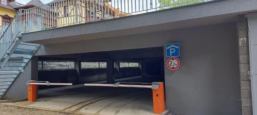 a parking garage with a parking sign next to a stairway at 4Roses Apartments in Smokovce